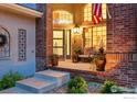 Inviting front porch with brick accents, potted plants, and comfortable seating area at 505 Orchard Dr, Louisville, CO 80027
