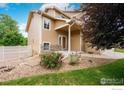 Inviting exterior with a cozy front porch, stone accents, charming front yard, and well-maintained landscaping at 5452 Rustic Ave, Firestone, CO 80504