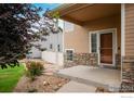 Inviting front porch with stone accents, a welcoming entrance, and landscaping with roses at 5452 Rustic Ave, Firestone, CO 80504