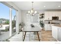 Dining area with sliding glass doors, modern chandelier, and ample natural light at 563 Green Mountain Dr, Erie, CO 80516