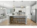 Modern kitchen with a large island, stainless steel appliances, and contemporary lighting at 563 Green Mountain Dr, Erie, CO 80516