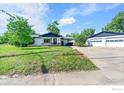 Exterior view of a home with a detached garage, driveway, and green lawn at 707 E Emma St, Lafayette, CO 80026