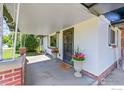 Welcoming front porch with decorative columns, potted flowers, and a secure front door at 707 E Emma St, Lafayette, CO 80026