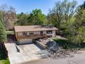 Aerial view showcasing the home's exterior, driveway, and surrounding landscape with mature trees at 7240 Glacier View Rd, Longmont, CO 80503