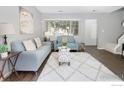 Inviting living room featuring updated flooring, large windows, modern furniture, and access to the stairway at 750 W Moorhead Cir # A, Boulder, CO 80305