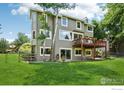 Back yard view of a home with a deck and a large grassy area at 7999 Centrebridge Dr, Niwot, CO 80503