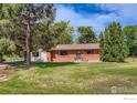 Charming red brick home with a well-maintained front yard and mature landscaping at 9449 Schlagel St, Longmont, CO 80503