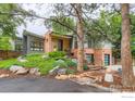 Striking home with brick and siding exterior, landscaped front yard, and mature trees at 955 Jasmine Cir, Boulder, CO 80304