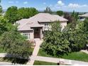 Beautiful two-story home with a tile roof, manicured landscaping, and mature trees at 11433 Decatur Ct, Westminster, CO 80234