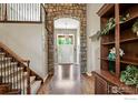 Grand foyer featuring a stone archway, hardwood floors, and a staircase at 11433 Decatur Ct, Westminster, CO 80234