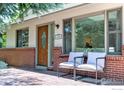 Inviting front porch featuring brick accents, a wooden door, and comfortable seating at 1245 Claremont Dr, Boulder, CO 80305