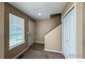 Inviting entryway featuring a white door, neutral walls, carpet, and a staircase at 1419 Red Mountain Dr # 126, Longmont, CO 80504