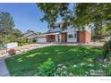 Charming two-story home with a lush green lawn, beautiful landscaping, and mature trees at 1590 Findlay Way, Boulder, CO 80305