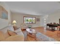 Bright living room featuring hardwood floors, a large window, and comfortable, neutral-toned furniture at 1590 Findlay Way, Boulder, CO 80305