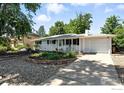 Inviting one-story home with a lovely front porch, driveway, and appealing rock garden and landscaping at 175 Iroquois Dr, Boulder, CO 80303