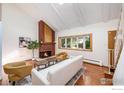 Inviting living room with a brick fireplace, skylight, and hardwood floors, perfect for relaxing and entertaining at 1945 Yank Ct, Golden, CO 80401
