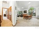 Open-concept living room with vaulted ceilings, large windows, and a dining area at 203 Springs Dr, Louisville, CO 80027