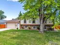 Attractive home featuring a stone facade, lush lawn, mature tree, and a two-car garage for inviting curb appeal at 2042 Garfield Ave, Louisville, CO 80027