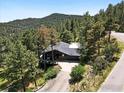 A high-angle landscape displays a quaint home surrounded by lush trees, a long driveway, and a basketball hoop at 2433 Linden Dr, Boulder, CO 80304
