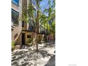 Multi-level townhome showcasing an exterior brick facade with garden beds and rock groundcover at 2900 Inca St # 24, Denver, CO 80202