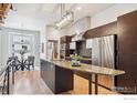 Stylish kitchen boasts stainless appliances, sleek cabinetry, granite island, and hardwood floors at 2900 Inca St # 24, Denver, CO 80202