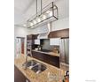 A gourmet kitchen featuring dark cabinets, granite countertops and stainless steel appliances at 2900 Inca St # 24, Denver, CO 80202