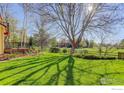 Expansive backyard featuring lush green grass, mature trees, and a wooden fence, creating a serene outdoor space at 4462 Wellington Rd, Boulder, CO 80301