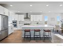 Bright kitchen with stainless steel appliances, white cabinetry, island with seating, and a dining area at 4825 Basalt Ridge Cir, Castle Rock, CO 80108