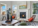 Cozy living room featuring a fireplace with a white mantel, hardwood floors, and natural light at 4825 Basalt Ridge Cir, Castle Rock, CO 80108