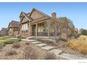 Charming home featuring a covered porch, stone accents, and well-manicured front yard at 555 Gallegos Cir, Erie, CO 80516