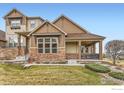 Charming home featuring a covered porch, stone accents, and beautifully landscaped front yard at 555 Gallegos Cir, Erie, CO 80516