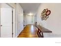 Inviting entryway featuring hardwood floors, a decorative mirror, and a view of the bright and welcoming interior at 6358 Union Ave, Firestone, CO 80504