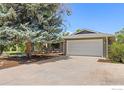 Exterior view featuring the home's garage, driveway, mature trees, and updated landscaping on a sunny day at 7261 Mount Meeker Rd, Longmont, CO 80503