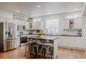 Bright kitchen with white cabinets, stainless steel appliances, and a unique island with seating at 8367 Devinney St, Arvada, CO 80005