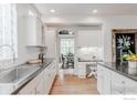 A sun-lit kitchen boasting white cabinets, modern appliances, and a seamless transition to the dining area at 8367 Devinney St, Arvada, CO 80005
