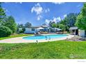 Expansive backyard features a sparkling swimming pool, lush lawn, and mature trees for ultimate relaxation and privacy at 8753 Crimson Clover Ln, Longmont, CO 80503