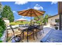 Outdoor dining area with seating for eight, overlooking a scenic view of the backyard and distant mountains at 8753 Crimson Clover Ln, Longmont, CO 80503