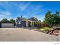 Blue house exterior with detached garage, mature tree and nicely kept lawn at 10731 Blue Jay Ln, Northglenn, CO 80233