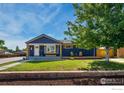 Charming home exterior with blue paint, front porch, green grass and attractive curb appeal at 10731 Blue Jay Ln, Northglenn, CO 80233