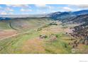 Expansive aerial view of the property showing rolling hills, lush greenery, and neighboring mountain ranges at 1125 Stone Canyon Rd, Longmont, CO 80503