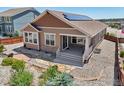 Exterior view of a house with solar panels, back patio and landscaped yard at 1297 Black Haw St, Elizabeth, CO 80107