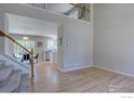 Open-concept home interior showcasing hardwood floors, a staircase, and views into the kitchen at 13382 Franklin St, Thornton, CO 80241