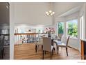 Bright dining room featuring hardwood floors, chandelier, and a glass-top table with seating for four at 1595 Bain Dr, Erie, CO 80516