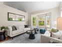 Beautiful living room with large mirror, bay window, light-colored walls and hardwood floors at 1595 Bain Dr, Erie, CO 80516