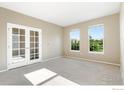 Spacious office featuring plush carpet, large windows, and glass panel french doors at 17216 E Trailmaster Dr, Parker, CO 80134