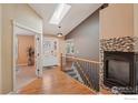 Inviting entryway with skylight, fireplace, and beautiful hardwood floors at 1806 Crestone Ct, Longmont, CO 80504