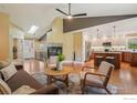 Open-concept living room boasts hardwood floors, a cozy fireplace, and seamless kitchen access at 1806 Crestone Ct, Longmont, CO 80504