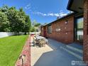 Outdoor patio with table and chairs next to the home's brick exterior at 1806 Crestone Ct, Longmont, CO 80504