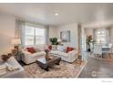 Inviting living room featuring a comfortable sofa, large windows, and elegant decor, perfect for relaxation at 1885 Mount Monroe Dr, Berthoud, CO 80513