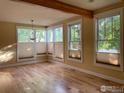 Spacious living room featuring gleaming hardwood floors and many large windows with pleated shades at 2204 Pine St, Boulder, CO 80302
